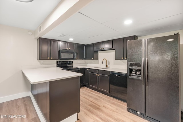 17 Westover Dr, Oak Ridge, TN 37830 - kitchen featuring black appliances, a sink, a peninsula, light wood-style flooring, and light countertops