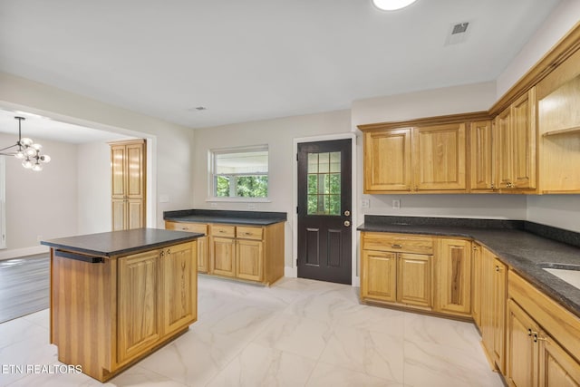 17 Westover Dr, Oak Ridge, TN 37830 - kitchen with dark countertops, a chandelier, a kitchen island, and light marble finish floors