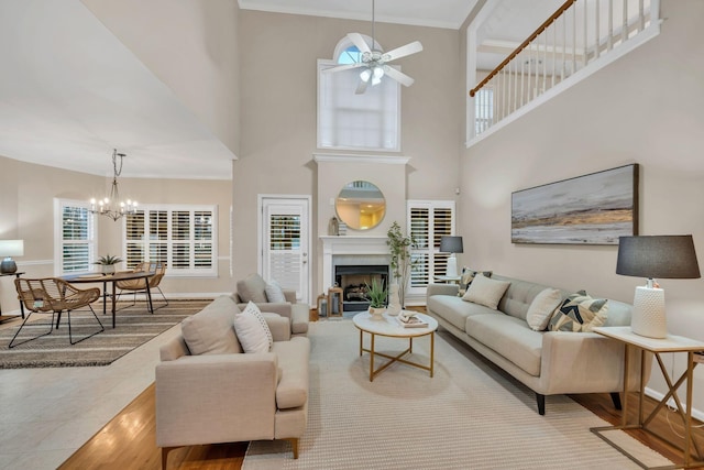 1034 Ridglea Dr, Burns, TN 37029 - living area featuring ceiling fan, a chandelier, ornamental molding, wood finished floors, and a fireplace
