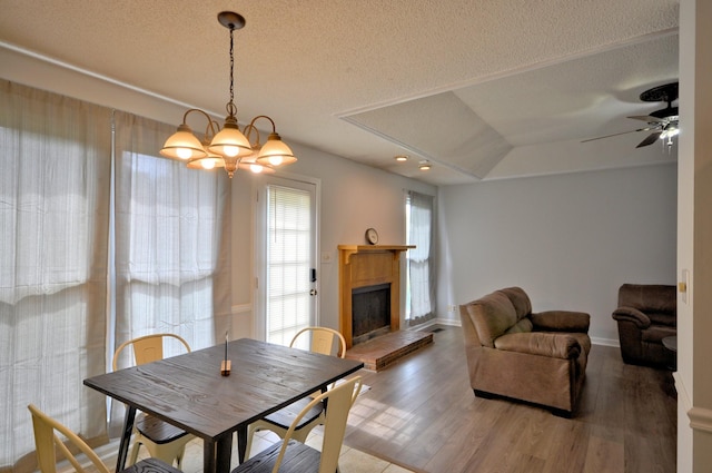 441 Bluff Dr, Clarksville, TN 37043 - dining area featuring wood finished floors, a textured ceiling, a fireplace with raised hearth, a ceiling fan, and baseboards