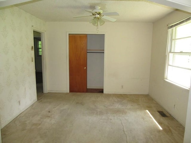 107 Jay Cir, Clarksville, TN 37040 - unfurnished bedroom with multiple windows, wallpapered walls, a closet, a ceiling fan, and carpet