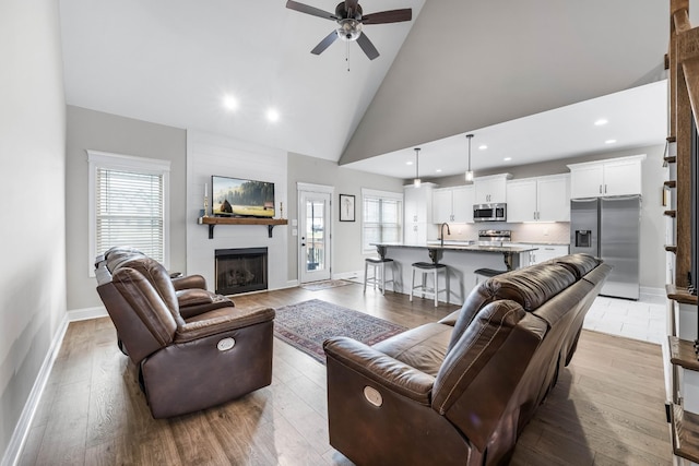 1103 Chagford Dr, Clarksville, TN 37043 - living room featuring ceiling fan, a large fireplace, high vaulted ceiling, recessed lighting, and wood finished floors