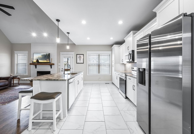 1103 Chagford Dr, Clarksville, TN 37043 - kitchen with appliances with stainless steel finishes, a sink, a fireplace, open floor plan, and white cabinets