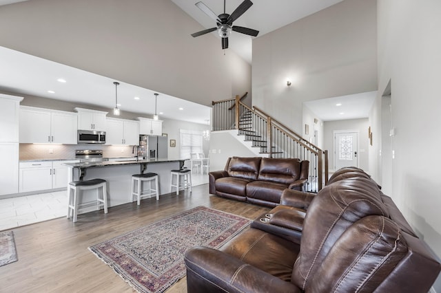 1103 Chagford Dr, Clarksville, TN 37043 - living area featuring stairway, ceiling fan, high vaulted ceiling, recessed lighting, and light wood-style floors