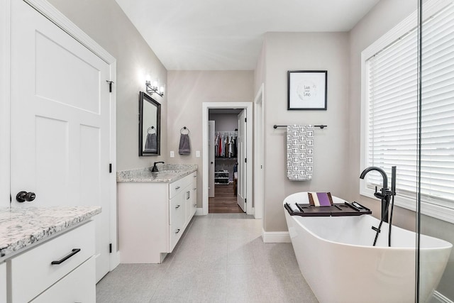 3050 Westowne Cir, Cookeville, TN 38501 - bathroom with vanity, baseboards, a soaking tub, a spacious closet, and tile patterned floors