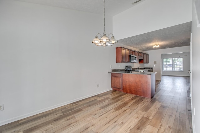 2026 Caladonia Way, Smyrna, TN 37167 - kitchen with stainless steel microwave, a peninsula, a chandelier, and light wood finished floors