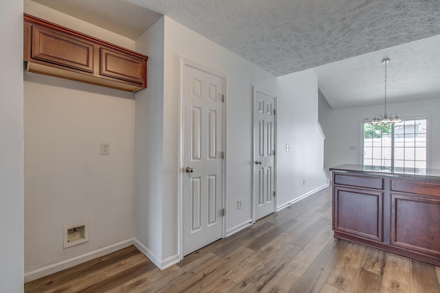 2026 Caladonia Way, Smyrna, TN 37167 - kitchen with light wood-style flooring, a chandelier, a textured ceiling, baseboards, and hanging light fixtures