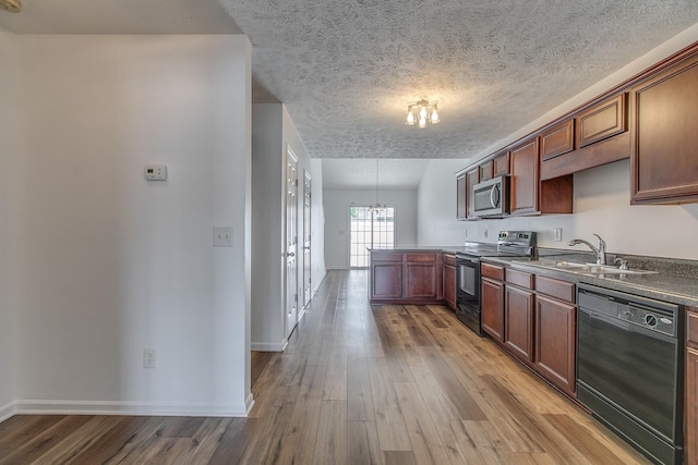 2026 Caladonia Way, Smyrna, TN 37167 - kitchen with black appliances, a chandelier, a peninsula, a sink, and light wood-type flooring