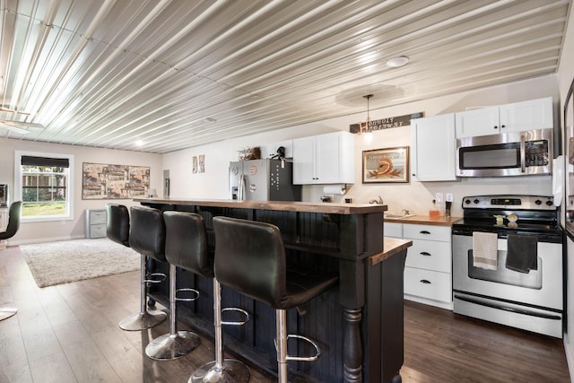 211 Hood St, Dover, TN 37058 - kitchen featuring stainless steel appliances, butcher block counters, a breakfast bar, and white cabinetry