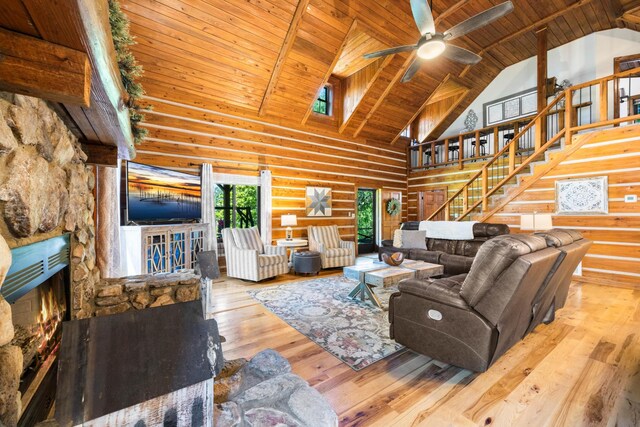 211 Hood St, Dover, TN 37058 - living area featuring high vaulted ceiling, wood ceiling with exposed beams, stairs, hardwood / wood-style flooring, and a stone fireplace