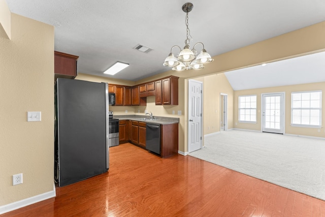 1036 Harold Lee Dr, Smyrna, TN 37167 - kitchen featuring appliances with stainless steel finishes, a sink, open floor plan, a chandelier, and light wood-style flooring