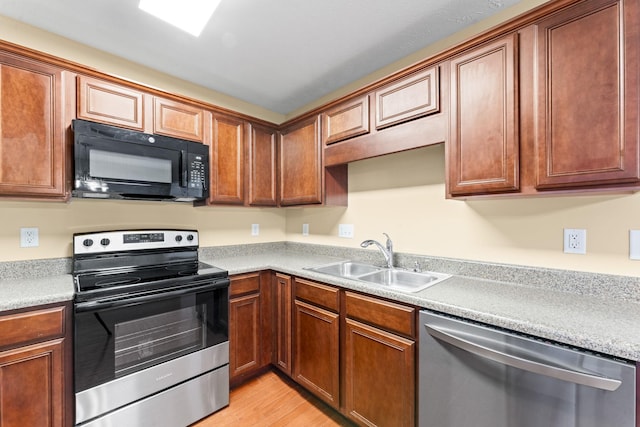 1036 Harold Lee Dr, Smyrna, TN 37167 - kitchen featuring appliances with stainless steel finishes, a sink, light wood-style floors, light countertops, and brown cabinetry