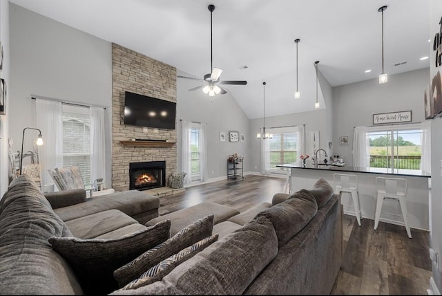 720 Jersey Dr, Clarksville, TN 37043 - living room with high vaulted ceiling, dark wood-type flooring, ceiling fan, a stone fireplace, and a chandelier