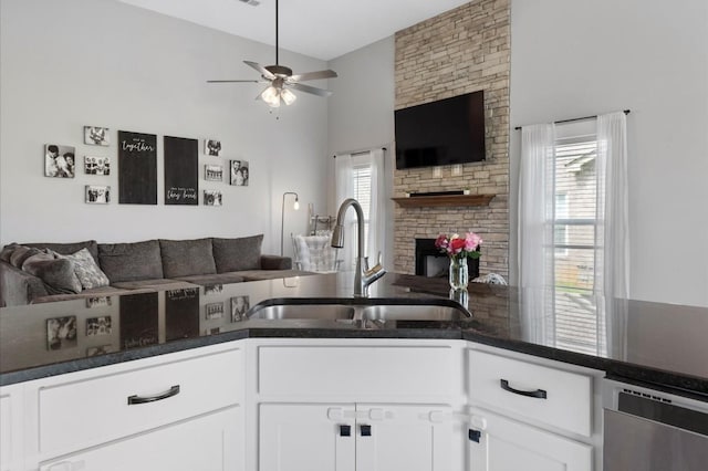 720 Jersey Dr, Clarksville, TN 37043 - kitchen featuring open floor plan, a sink, dishwasher, a stone fireplace, and white cabinets
