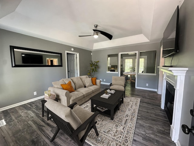 1016 Silver Point Dr, Murfreesboro, TN 37130 - living area featuring a tray ceiling, a ceiling fan, baseboards, wood finished floors, and a fireplace