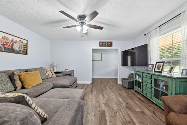 530 Maplewood Dr, Cornersville, TN 37047 - living room featuring wood finished floors, a textured ceiling, a ceiling fan, and baseboards