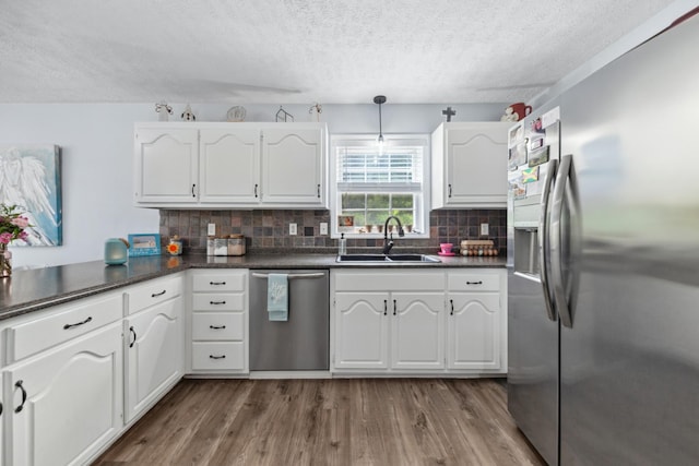 530 Maplewood Dr, Cornersville, TN 37047 - kitchen with a sink, appliances with stainless steel finishes, dark countertops, a textured ceiling, and white cabinetry