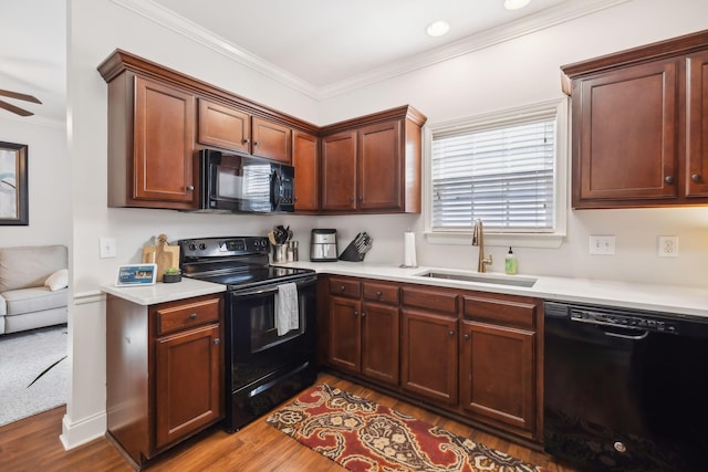 816 General Cabot Ct, Murfreesboro, TN 37129 - kitchen featuring black appliances, a sink, wood finished floors, light countertops, and ornamental molding