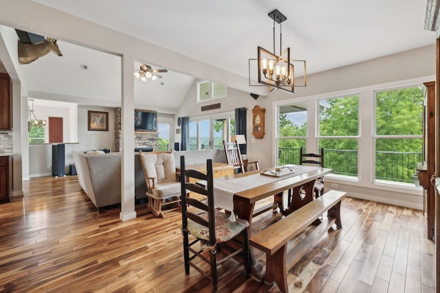 225 Ferguson Creek Rd, Sparta, TN 38583 - dining room featuring a stone fireplace, light wood-style flooring, lofted ceiling, a chandelier, and ceiling fan