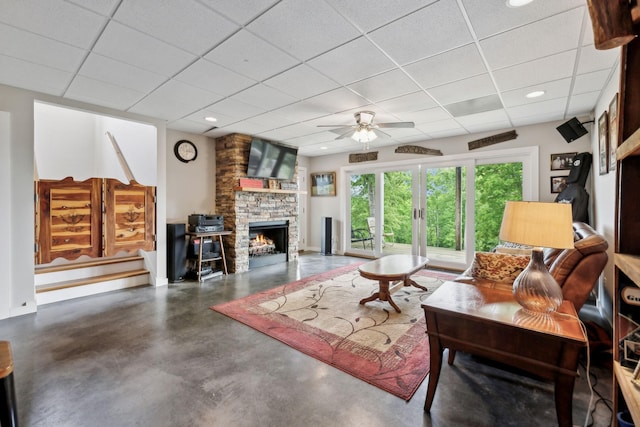 225 Ferguson Creek Rd, Sparta, TN 38583 - living room featuring concrete flooring, a drop ceiling, a ceiling fan, a fireplace, and baseboards