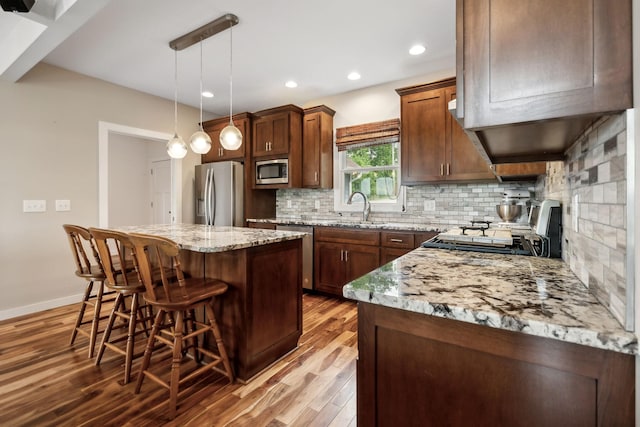 225 Ferguson Creek Rd, Sparta, TN 38583 - kitchen featuring appliances with stainless steel finishes, a kitchen island, light wood-type flooring, a kitchen breakfast bar, and recessed lighting