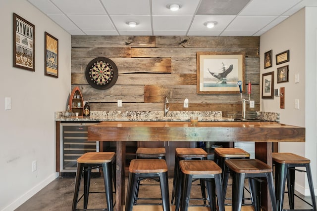 225 Ferguson Creek Rd, Sparta, TN 38583 - indoor wet bar featuring beverage cooler, baseboards, a paneled ceiling, wooden walls, and an accent wall