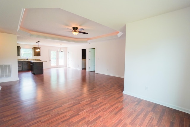 41 Haven Way, Westmoreland, TN 37186 - unfurnished living room featuring a tray ceiling, ceiling fan, dark wood-style floors, a chandelier, and baseboards