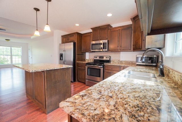 41 Haven Way, Westmoreland, TN 37186 - kitchen featuring appliances with stainless steel finishes, a sink, a center island, wood finished floors, and light stone counters