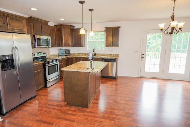 41 Haven Way, Westmoreland, TN 37186 - kitchen with appliances with stainless steel finishes, dark wood-style flooring, a chandelier, light stone countertops, and pendant lighting
