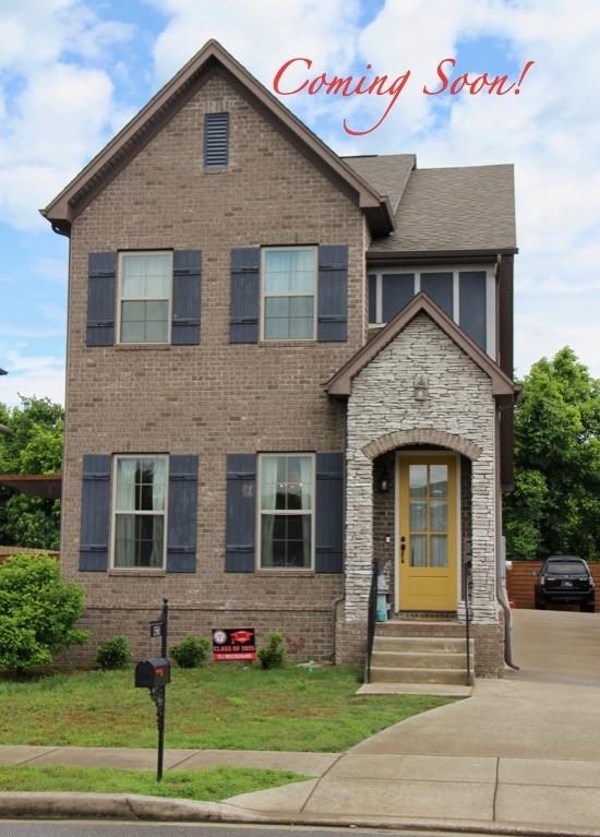1561 Brockton Ln, Nashville, TN 37221 - view of front of house featuring a front lawn, brick siding, and entry steps