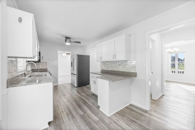 2746 Field Ct, Woodlawn, TN 37191 - kitchen featuring freestanding refrigerator, a sink, white cabinets, backsplash, and ornamental molding