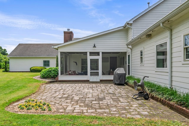 2111 Lovelace Ln, Murfreesboro, TN 37130 - back of property featuring a sunroom, a chimney, a patio area, and a lawn