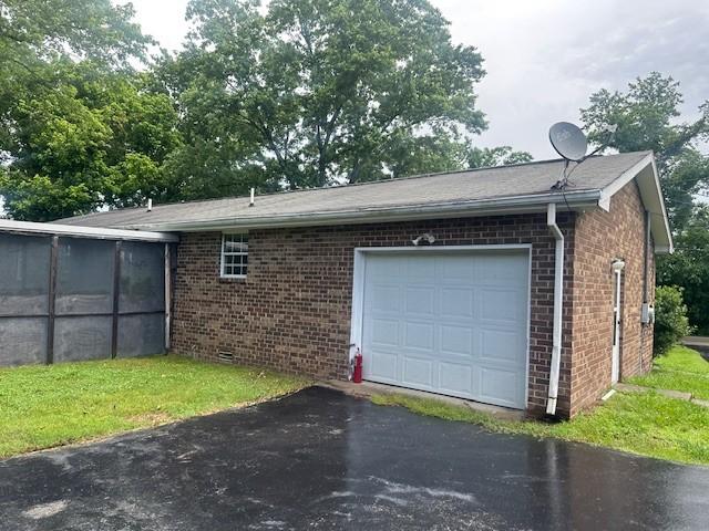 2045 Nonaville Rd, Mount Juliet, TN 37122 - view of side of property featuring brick siding, a garage, asphalt driveway, and a sunroom