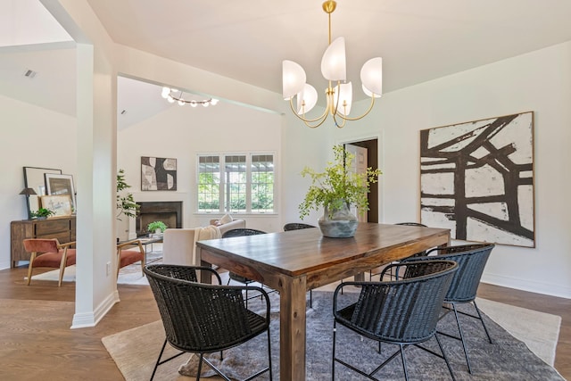 529 Wilson Run, Brentwood, TN 37027 - dining area with a chandelier, baseboards, lofted ceiling, a fireplace, and wood finished floors