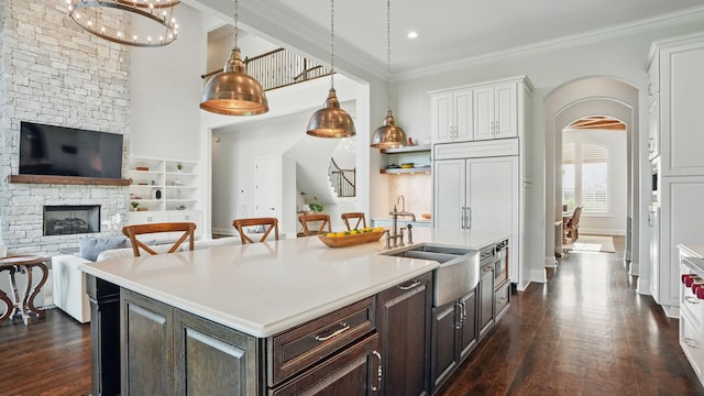 4740 Edwardian Trce, Franklin, TN 37067 - kitchen featuring a sink, arched walkways, dark brown cabinetry, light countertops, and ornamental molding