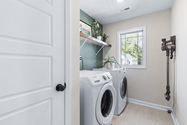 1013 Brightwood Ct, Clarksville, TN 37043 - laundry area with washing machine and clothes dryer, baseboards, light tile patterned flooring, and a textured ceiling
