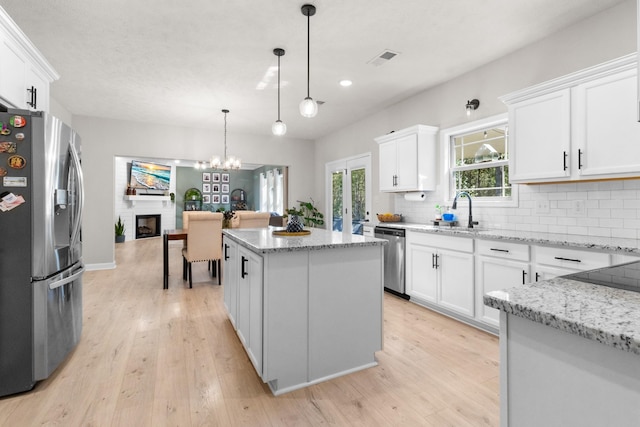 1013 Brightwood Ct, Clarksville, TN 37043 - kitchen with appliances with stainless steel finishes, a sink, a center island, backsplash, and white cabinetry