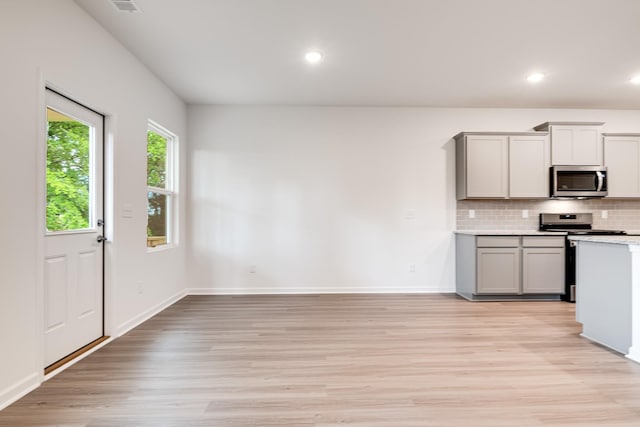 316 Deacon Ln, White House, TN 37188 - kitchen featuring appliances with stainless steel finishes, gray cabinetry, light wood-style flooring, tasteful backsplash, and light countertops