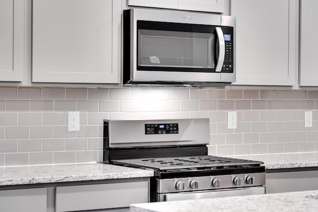 316 Deacon Ln, White House, TN 37188 - kitchen with appliances with stainless steel finishes, backsplash, and light stone countertops