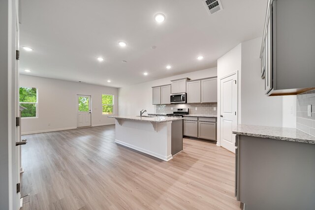 316 Deacon Ln, White House, TN 37188 - kitchen with stainless steel appliances, gray cabinetry, a sink, tasteful backsplash, and light wood-style flooring