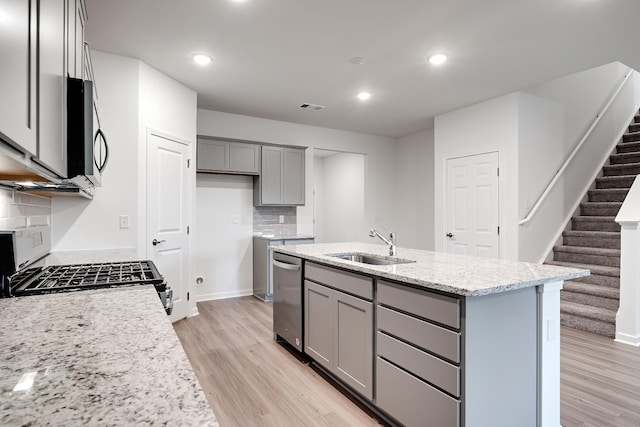 316 Deacon Ln, White House, TN 37188 - kitchen featuring appliances with stainless steel finishes, gray cabinetry, light wood-style flooring, decorative backsplash, and recessed lighting