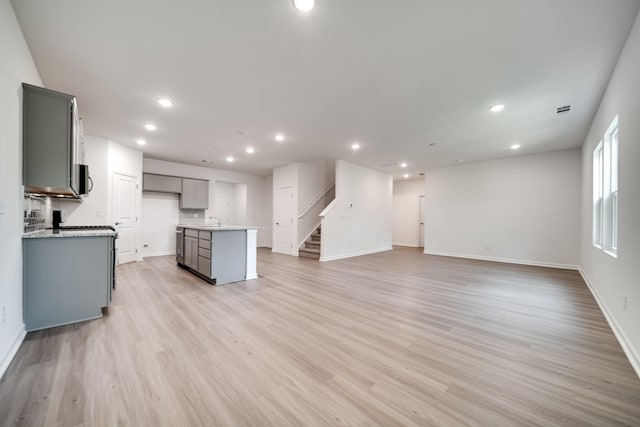 316 Deacon Ln, White House, TN 37188 - unfurnished living room featuring a sink, stairs, light wood-type flooring, baseboards, and recessed lighting