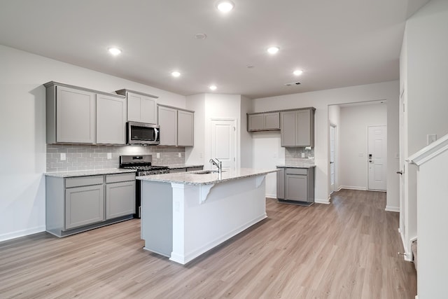 316 Deacon Ln, White House, TN 37188 - kitchen with stainless steel appliances, gray cabinets, decorative backsplash, light wood-type flooring, and a sink
