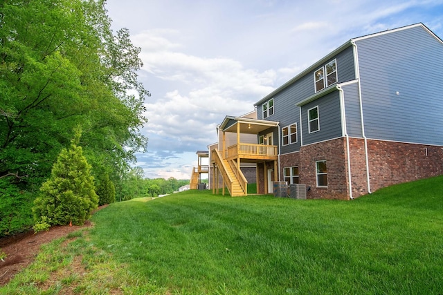 316 Deacon Ln, White House, TN 37188 - back of house featuring stairway, brick siding, central AC, a deck, and a lawn