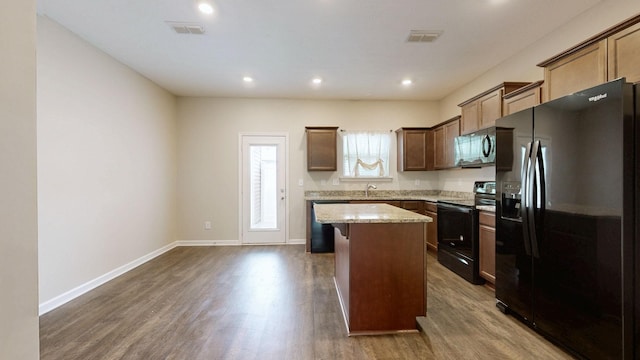 4117 Saddlecreek Way, Antioch, TN 37013 - kitchen featuring black appliances, a kitchen island, dark wood-style floors, light stone counters, and recessed lighting