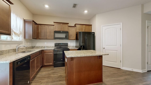 4117 Saddlecreek Way, Antioch, TN 37013 - kitchen with black appliances, a sink, dark wood-style flooring, a center island, and light stone countertops