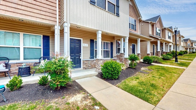 4117 Saddlecreek Way, Antioch, TN 37013 - view of exterior entry with a residential view, a porch, board and batten siding, and stone siding