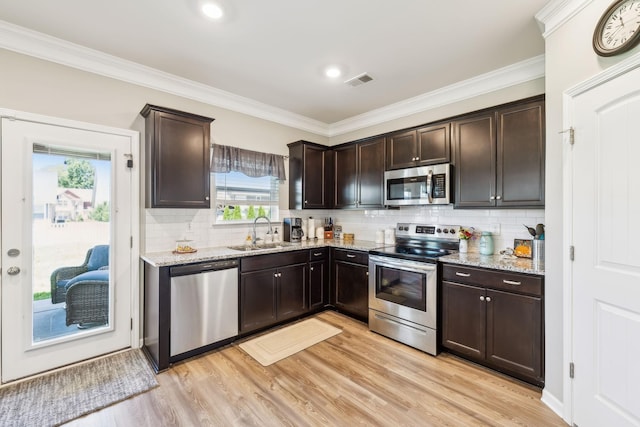 319 Petunia Dr, Smyrna, TN 37167 - kitchen featuring stainless steel appliances, a sink, light stone counters, dark brown cabinetry, and healthy amount of natural light
