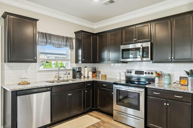 319 Petunia Dr, Smyrna, TN 37167 - kitchen featuring stainless steel appliances, a sink, light stone counters, crown molding, and tasteful backsplash
