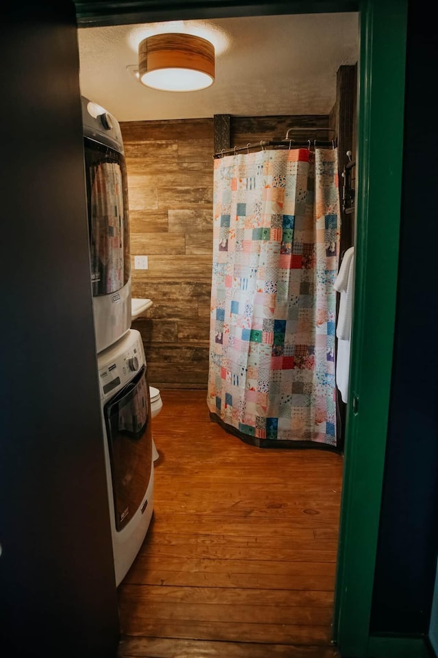 587 Lakes Rd, Tracy City, TN 37387 - bathroom with wooden walls, wood finished floors, and estacked washer and dryer